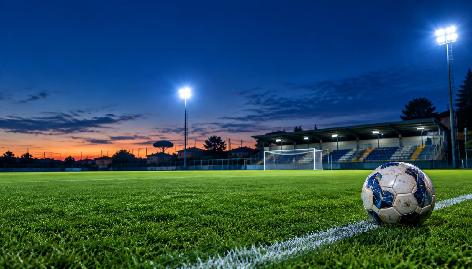 Campo da calcio illuminato al tramonto
